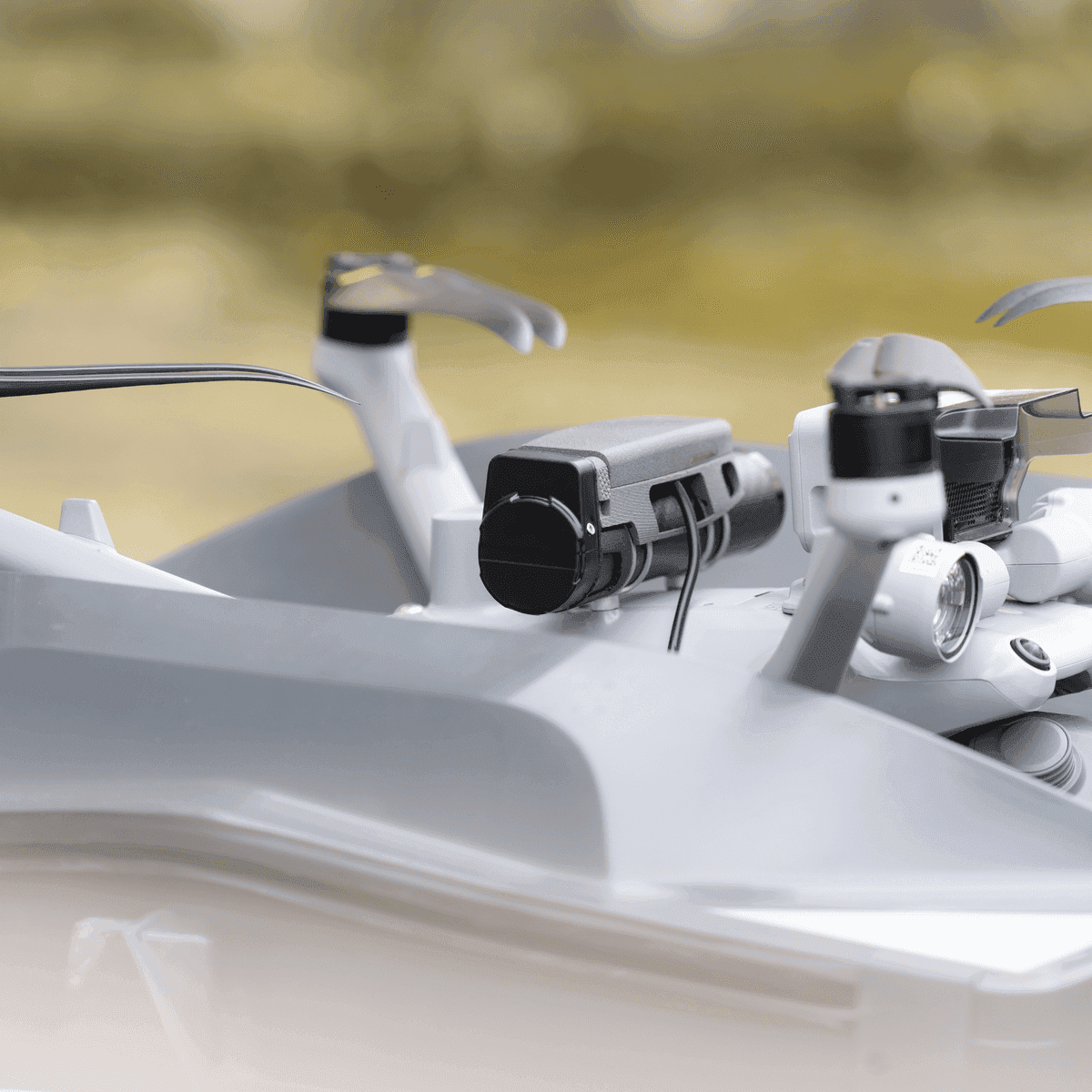 En närbild av en drönare med avancerade sensorer och propellrar, mot en suddig bakgrund.