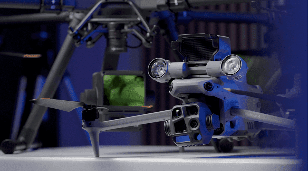 En avancerad Matrice 4T-drönare med flera sensorer, kameror, spotlight och högtalare visas i en futuristisk miljö, redo för tekniska uppdrag.