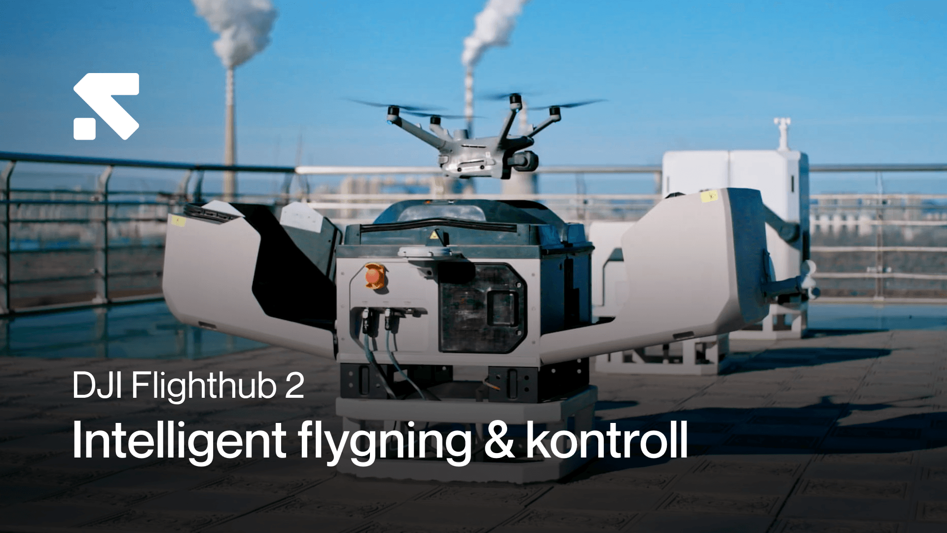 En drönare lyfter från en plattform på ett industriellt tak med rökpelare i bakgrunden, illustrerande intelligent flygning och kontroll.