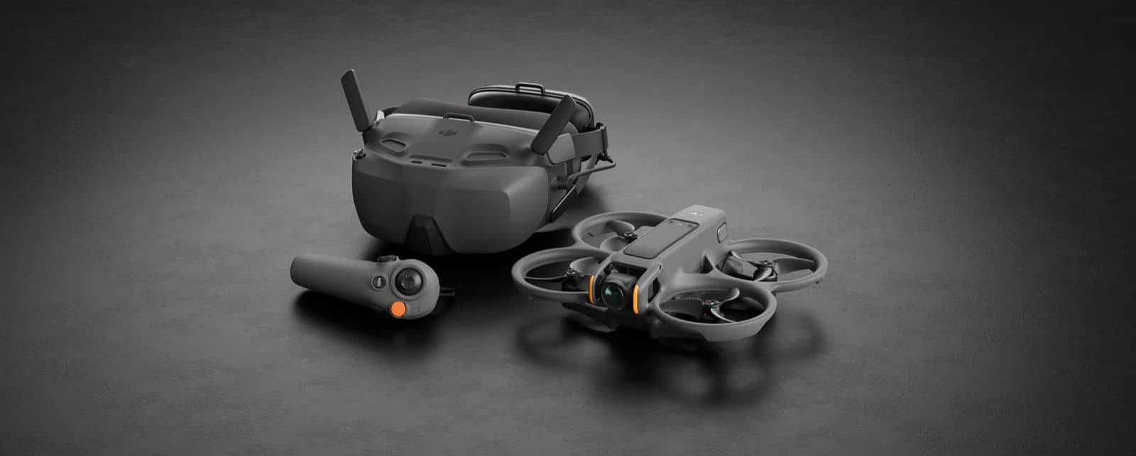 En avancerad drönare med tillhörande VR-headset och handkontroll ligger på en mörk yta, redo för flygning.