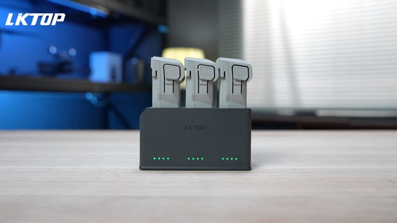 En laddningsstation med tre enheter placerade i en modern, teknisk miljö med blå belysning i bakgrunden.