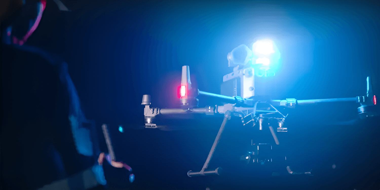 En drönare med en LP35 monterad på toppen, styrd av en person med en fjärrkontroll.