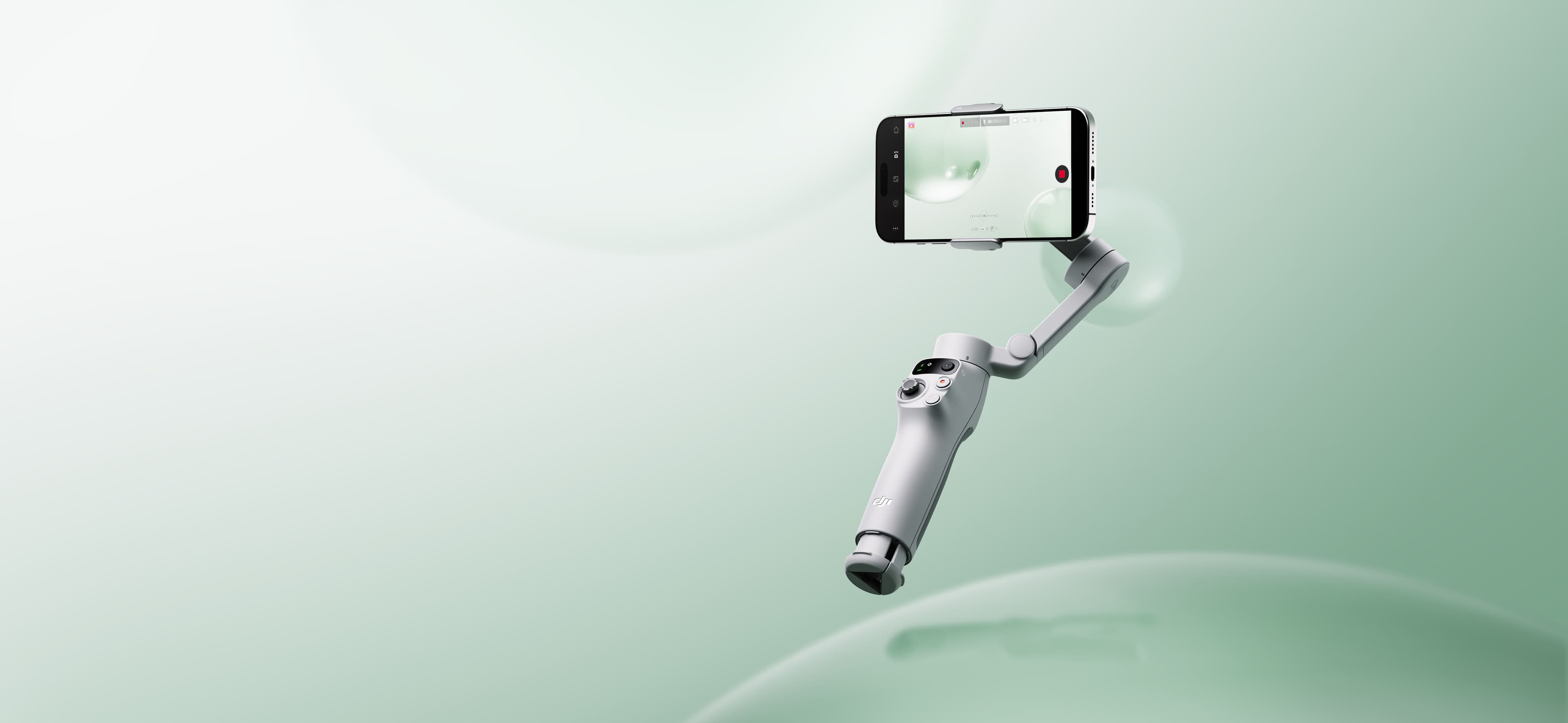 "En smartphone monterad på en gimbal svävar mot en mjukt grön bakgrund, redo för stabil videoinspelning."