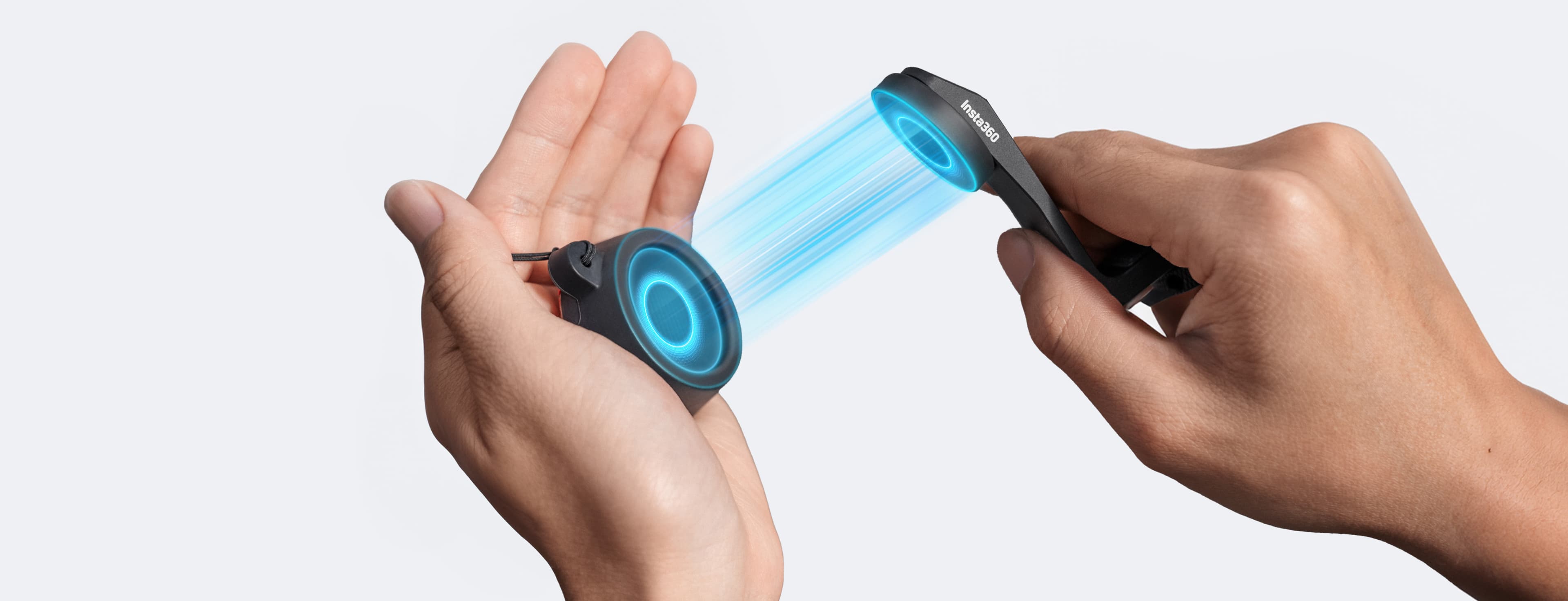 En hand håller en magnetisk fästanordning som kopplas till en annan enhet med ett blått ljus